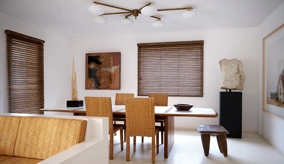 A mid-century modern dining room features Wood Blinds and valance made of 2-inch Exotic Zebrano for a striking look