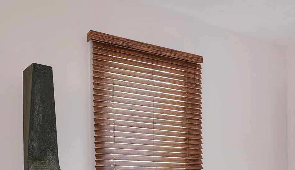 2-inch Wood Blinds made of Exotic Zebrano are installed with a valance on a tall window next to a piece of art