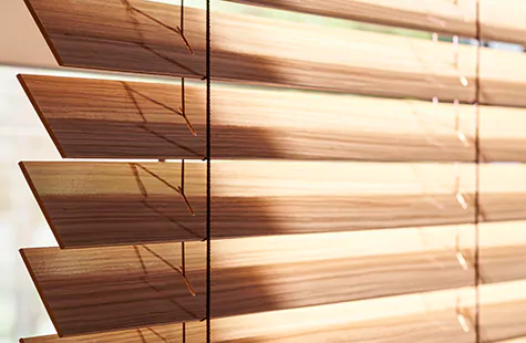 Wood blinds made with exotic wood in an intricate Zebrano finish are a refined choice for bay window blinds