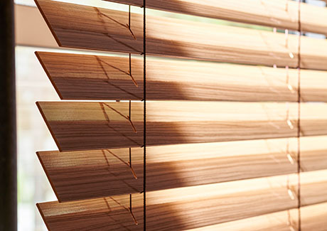Small window blinds made of 2-inch Exotic wood in Zebrano add warm wood tones and visual texture to a window