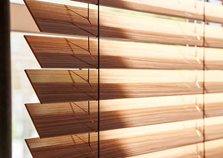 Small window blinds made of 2-inch Exotic wood in Zebrano add warm wood tones and visual texture to a window