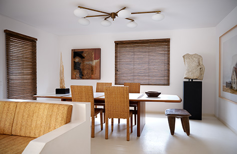 Window coverings in a mid-century modern dining room include Wood Blinds made of 2-inch Exotic wood in Zebrano