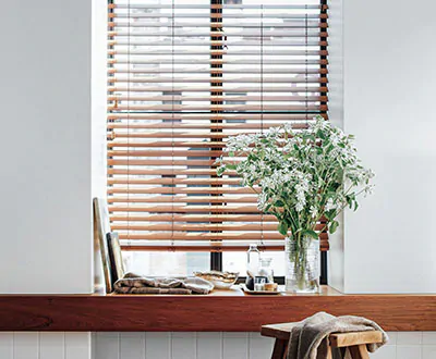 Wood Blinds made of 2-inch Faux in Teak are a functional alternative to Scandinavian curtains on a small window with a ledge