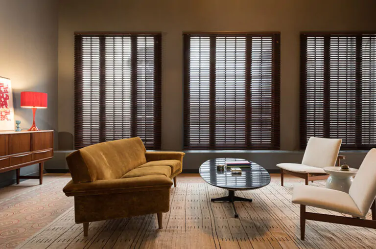 A muted tone and minimalist design throughout the space reveals the best type of blinds for living room windows