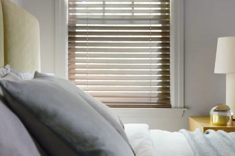 Learn how to measure for blinds like these Wood Blinds made of 2-inch Laminated wood in Light Walnut in a guest bedroom