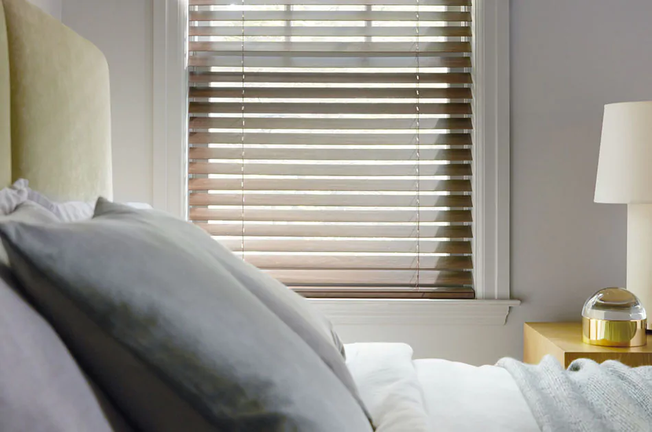 Learn how to measure for blinds like these Wood Blinds made of 2-inch Laminated wood in Light Walnut in a guest bedroom