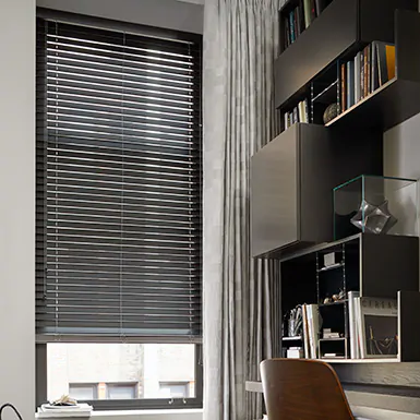 A modern office features wood blinds for tall windows made of 2-inch wood in Matte Coal for a high-contrast look