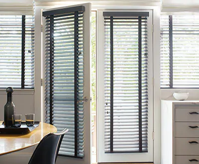 Two doors that lead to the backyard from the dining room feature Wood Blinds made of 2-inch Painted Bamboo in Coal