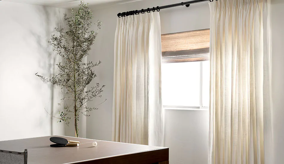 Basement window curtains made of Tailored Pleat Drapery of Luxe Linen in Oyster add texture and color to a basement rec room