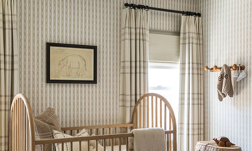 A nursery has many textures like Tailored Pleat Drapery of Aberdeen in Bisque and Woven Wood shade of Laguna in Shell