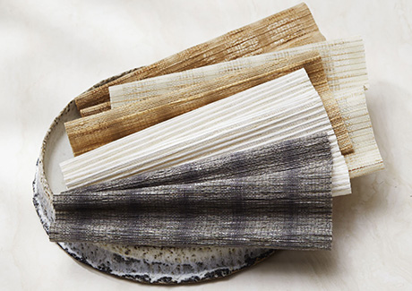 Woven Wood Shade swatches made of Artisan Weaves Coastline in several colors lay invitingly in a stone bowl