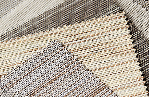 Woven shades swatches of the Naturals collection lay flat on a table and show their varying textures and natural colors