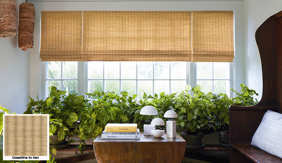 One of the window treatment trends 2024 is the use of woven textiles seen on these Waterfall Woven Wood Shades in a sunroom