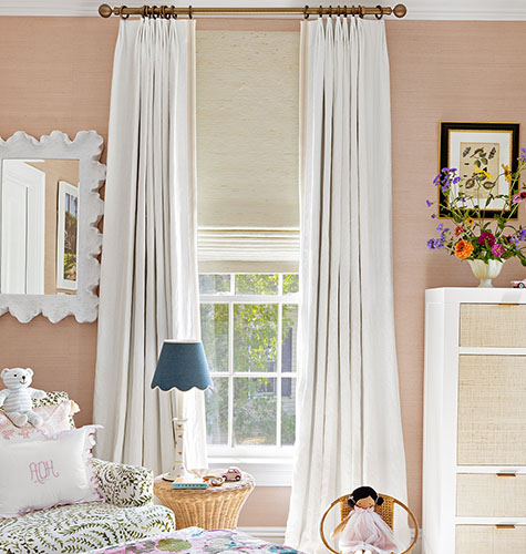 Nursery curtains made of Tailored Pleat Drapery in Linen, Ivory, offer a soft off-white color to peach colored walls